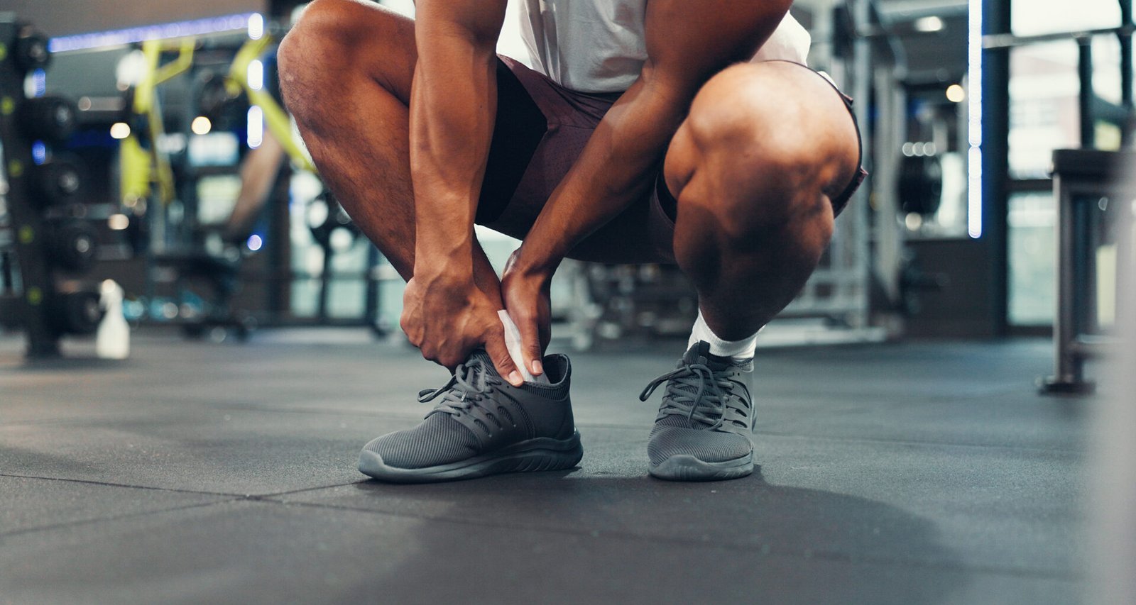 Man holding his foot in pain to show why feet hurt after workouts.
