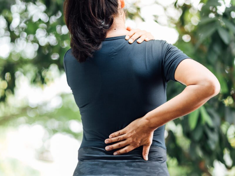 Woman with back pain showing signs of her body not recovering properly.