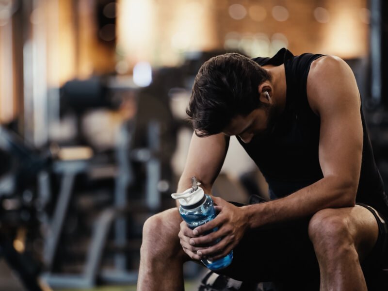 A person resting on a gym bench to recover faster and improve performance.