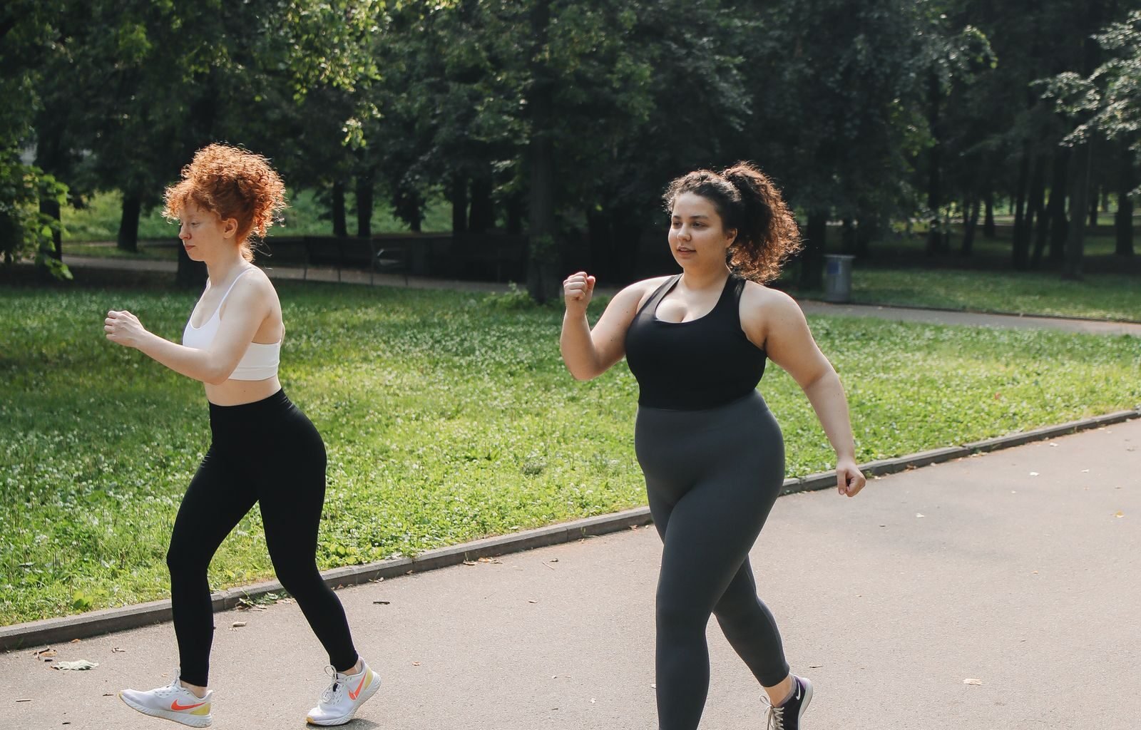 Two women brisk walking on a park path using the japanese walking method