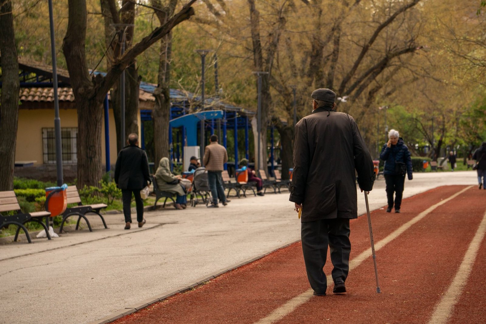 Tai chi lymphatic walking for beginners: older adult walking slowly outdoors in a park