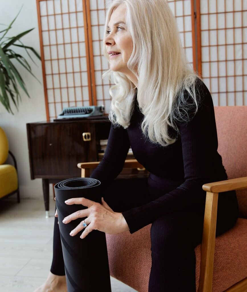 Chair yoga for seniors: older woman seated on a chair at home